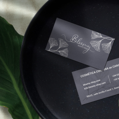 Clean minimal business card mockup on black stone plate with leaf background. PSD file.